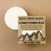 Rock Creek Soaps conditioner bar with packaging on a brown background