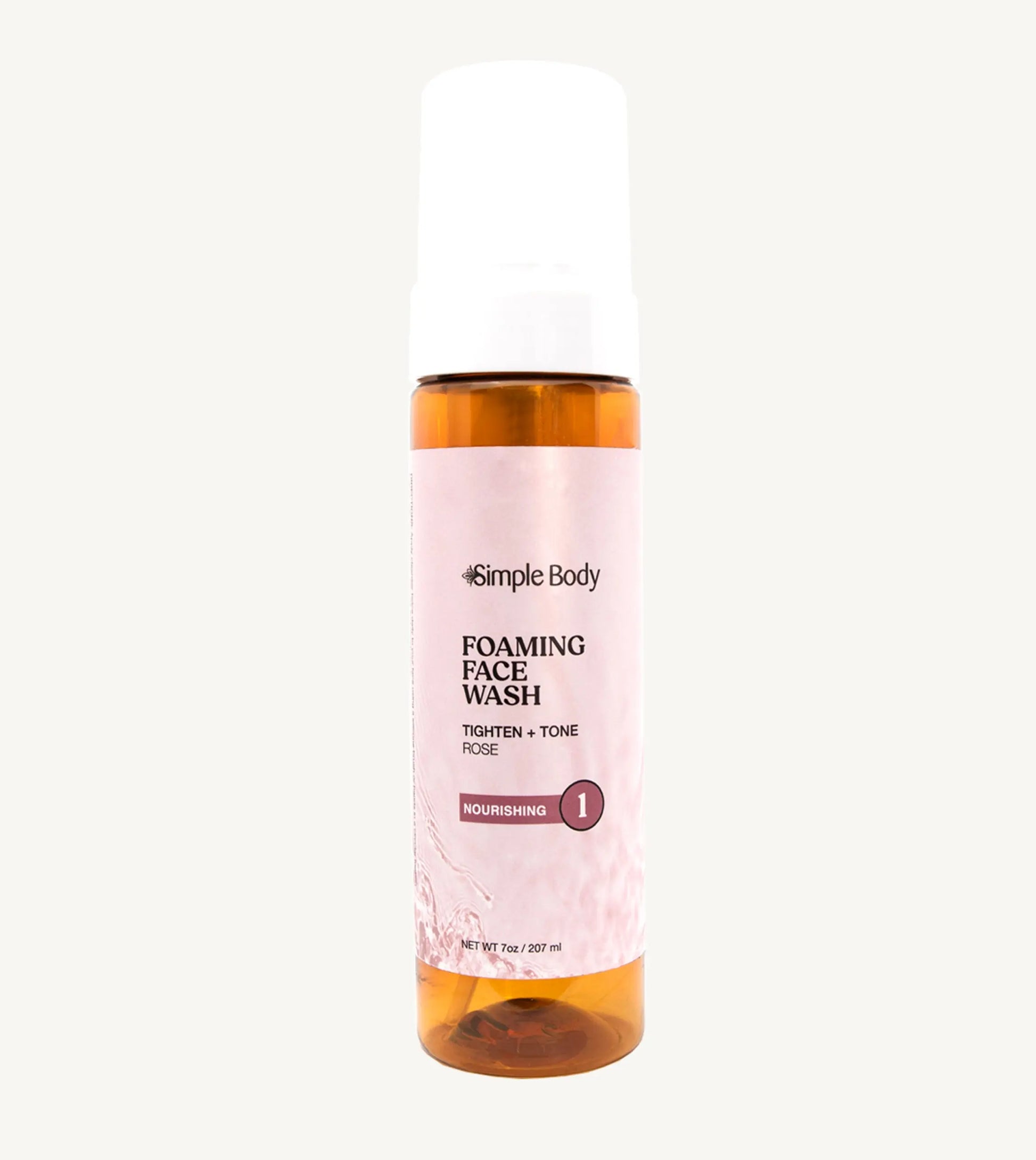 An amber colored pump bottle of Simple Body Foaming Face Wash with pink rose floral water visible inside.
