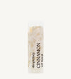 An oval lip balm tube with a label that reads 'Cinnamon Lip Balm'. The packaging is clear, revealing the off-white product inside.