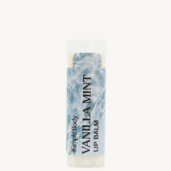 An oval lip balm tube with a label showing the scent 'Vanilla Mint' and a blue and white label.