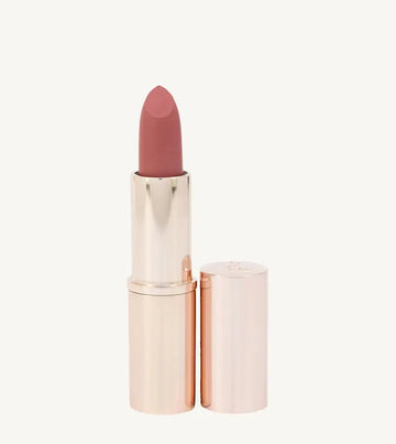 A photo of Pure Anada's Lip Stick in a rose gold tube with a pin / rose color on a tan background.