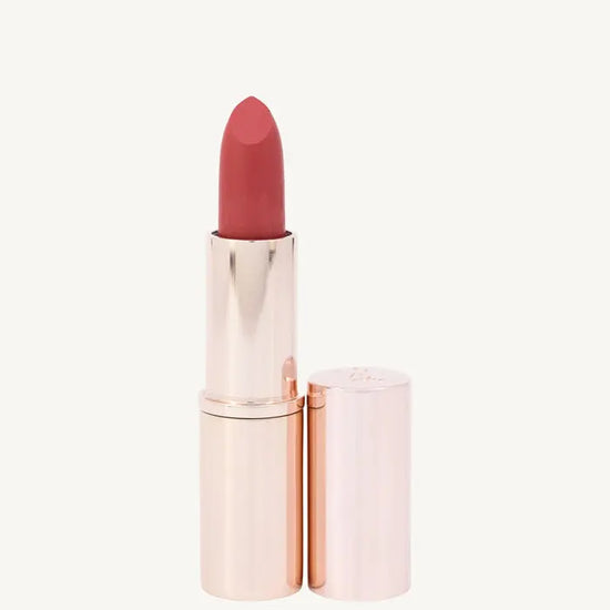 A photo of Pure Anada's Lip Stick in Prestige in a rose gold tube and a pinkish orange tint on a tan background.