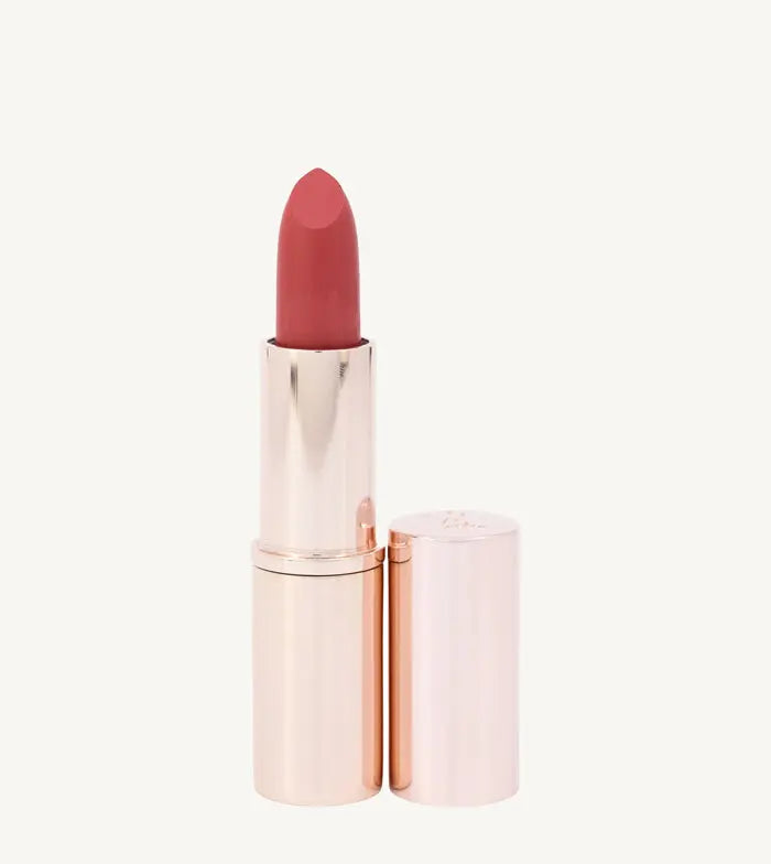 A photo of Pure Anada's Lip Stick in Prestige in a rose gold tube and a pinkish orange tint on a tan background.