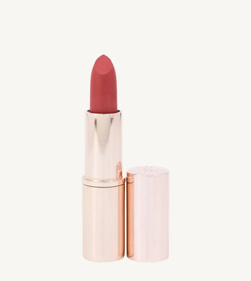 A photo of Pure Anada's Lip Stick in Prestige in a rose gold tube and a pinkish orange tint on a tan background.