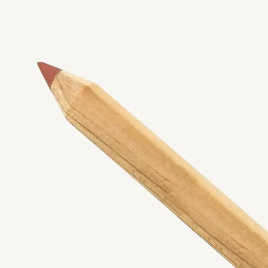 A photo of Pure Anada's Lip Pencil in a natural wood color and the tip is a warm rust color on a tan background.