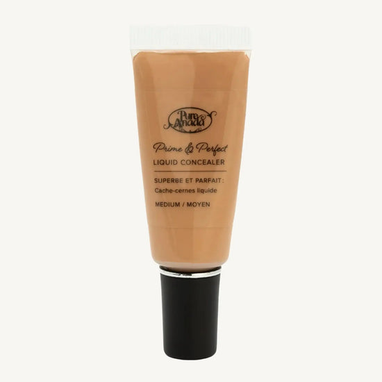 A photo of a tube of Pure Anada's Liquid Concealer in Medium which is a medium to dark tan color on a tan background.