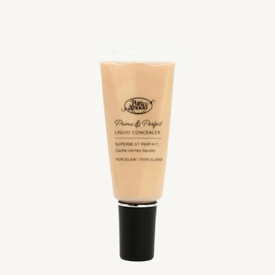 A photo of Pure Anada's Liquid Concealer in Porcelain which is a very light beige color on a tan background.