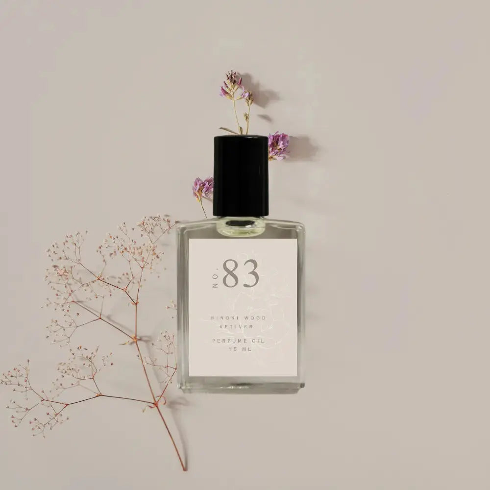 Perfume bottle labeled 'No. 83' with flowers on a beige background