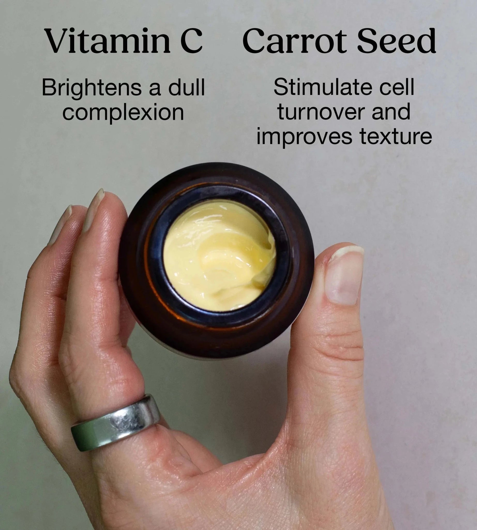 A hand holding a yellow cream by Simple Body called Beauty Balm calling out the benefits of Vitamin C which Brightens Dull Complexion and Carrot Seed Which Stimulates cell turnover and improves texture