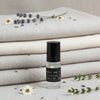 Roll-on bottle of lavender perfume with lavender flowers and fabric in the background