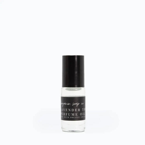 Perfume oil bottle with black cap and label on a white background