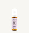 An amber colored pump bottle of Simple Body Foaming Face Wash in lavender that says "Relax + Soothe"