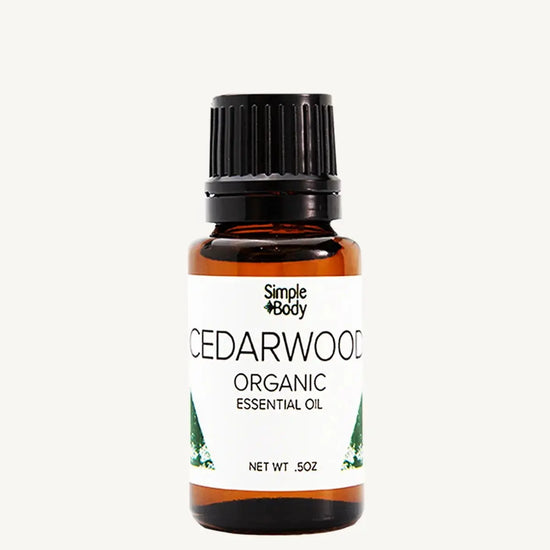 Bottle of Simple Body Cedarwood Organic Essential Oil on a white background