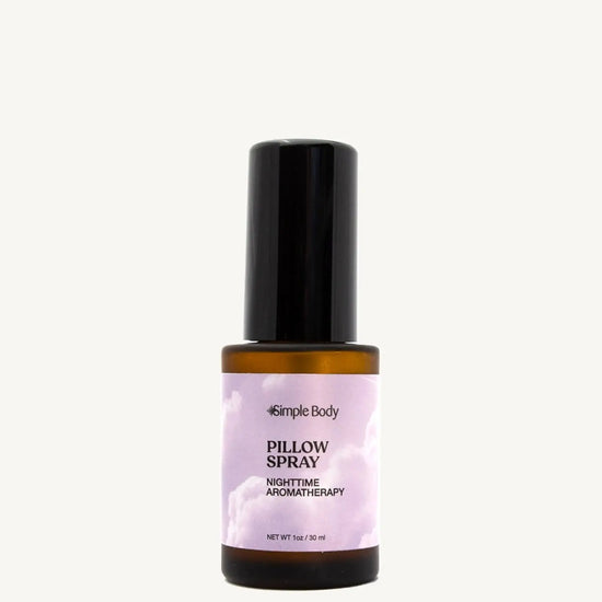 A small amber colored mist bottle labeled Pillow Spray with purple and white color label, indicating it is a nighttime aromatherapy product.