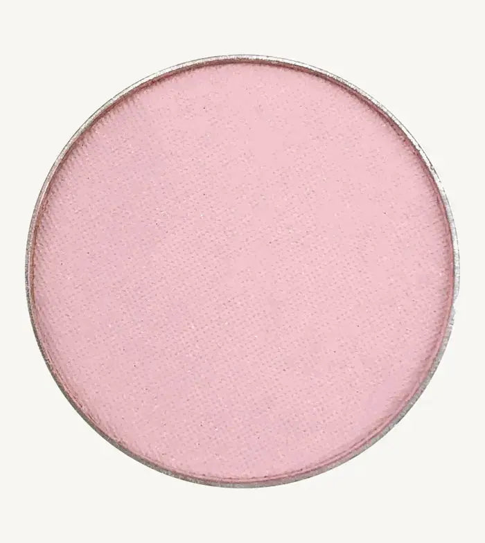 A photo of Pure Anada's Pressed Eye Color Water Lily which is a ballet pink on a tan background.