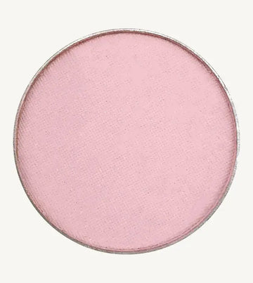 A photo of Pure Anada's Pressed Eye Color Water Lily which is a ballet pink on a tan background.