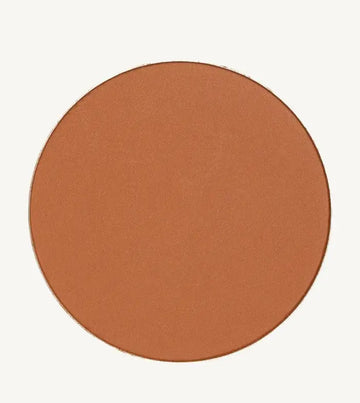 A photo of Pure Anada's Global Pressed Foundation powder which is a cinnamon brown orange color on a tan background.