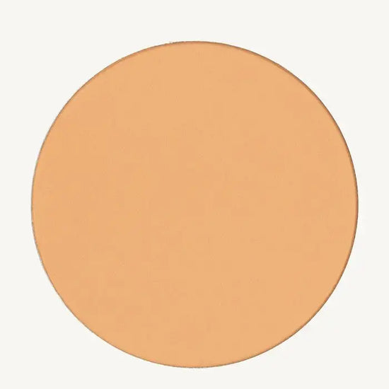 A photo of Pure Anada's Pressed Sheer Matte Foundation Powder in Light which is a warm beige color on a tan background.