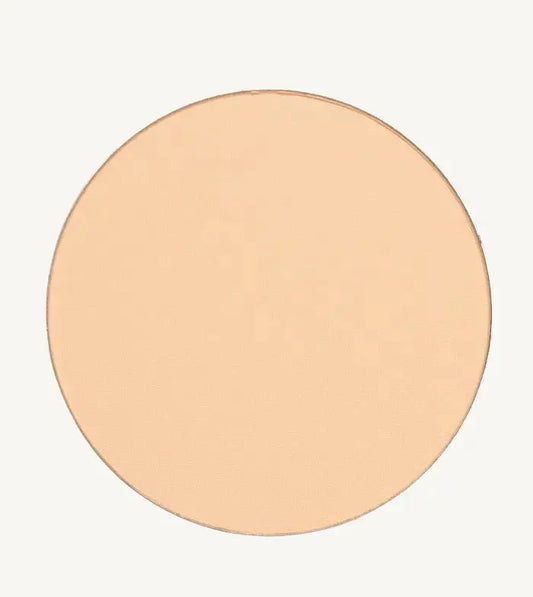 A photo of Pure Anada's Pressed Sheer Foundation Powder in Porcelain which is a light beige with a hint of peach color on a tan background.