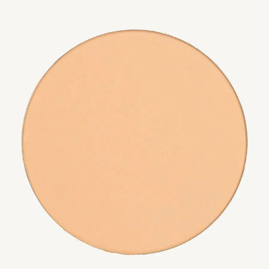 A photo of Pure Anada's Pressed Sheer Foundation in Very Fair which is a medium beige with light overtones and a warm feel on a tan background.