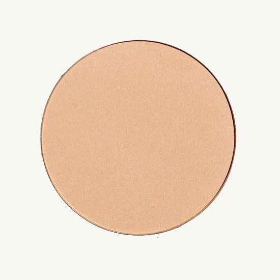 A photo of Pure Anada's Pressed Translucent Finishing Powder in Glow which is a warm peach with a slight shimmer on a tan background.