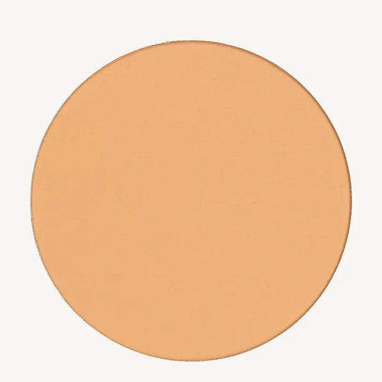 A photo of Pure Anada's Pressed Sheer Matte Foundation Powder in Light which is a warm beige color on a tan background.