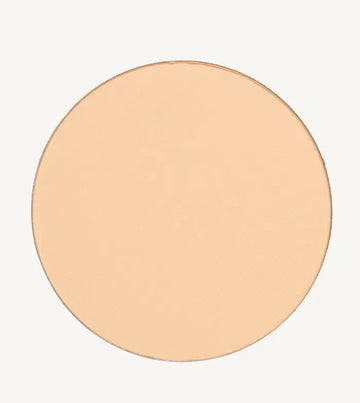 A photo of Pure Anada's Pressed Sheer Foundation Powder in Porcelain which is a light beige with a hint of peach color on a tan background.