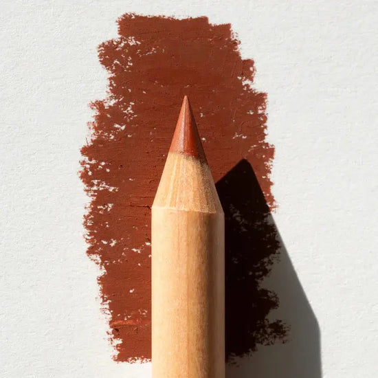 Brown makeup pencil with a swatch of color on a light gray background