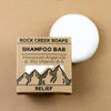 Rock Creek Soaps shampoo bar with packaging on a beige background
