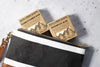 Two shampoo bars from Rock Creek Soaps on a gray surface with a black pouch.
