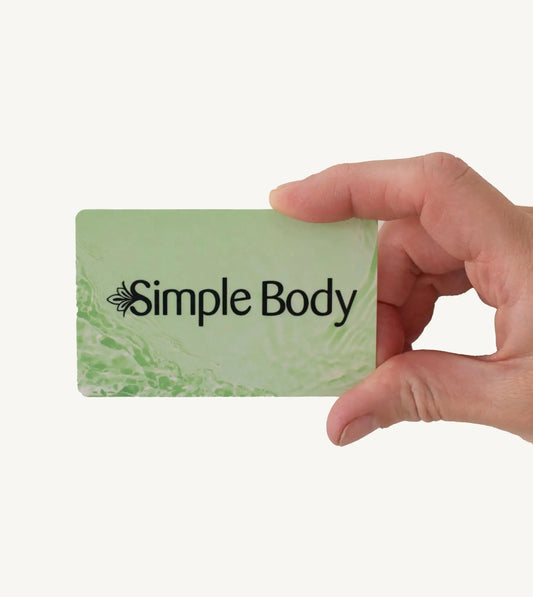 Hand holding a green gift card with 'Simple Body' logo against a white background