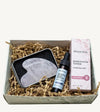 Simple Body Gua Sha gift set including a gua sha tool, Nightly Face Serum, and a Rosewater Toner in a box with crinkled paper
