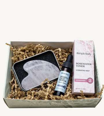 Simple Body Gua Sha gift set including a gua sha tool, Nightly Face Serum, and a Rosewater Toner in a box with crinkled paper