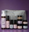 A skincare kit designed for anti aging and age supporting skin type with a gray pouch on a purple background