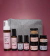 A skincare kit designed for Normal or Dry skin products with a gray cosmetic bag on a pink background