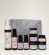 A skincare kit designed for sensitive skin with a gray pouch on a light yellow background