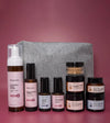 A skincare kit designed for Normal or Dry skin products with a gray cosmetic bag on a pink background