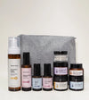 A skincare kit designed for sensitive skin with a gray pouch on a light yellow background