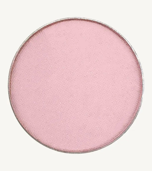 A photo of Pure Anada's Pressed Eye Color Water Lily which is a ballet pink on a tan background.