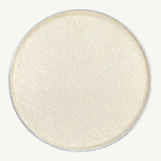 A photo of Pure Anada's Pressed Eye Color in Whisper which is an off-white color on a tan background.
