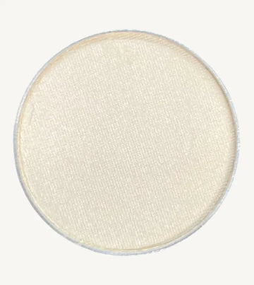 A photo of Pure Anada's Pressed Eye Color in Whisper which is an off-white color on a tan background.