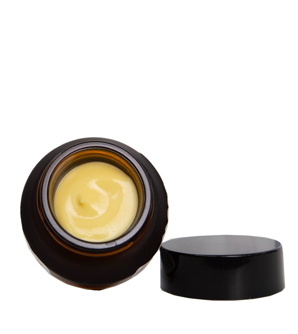 A photo of our mini beauty balm with the lid off showing the creamy yellow moisturizer