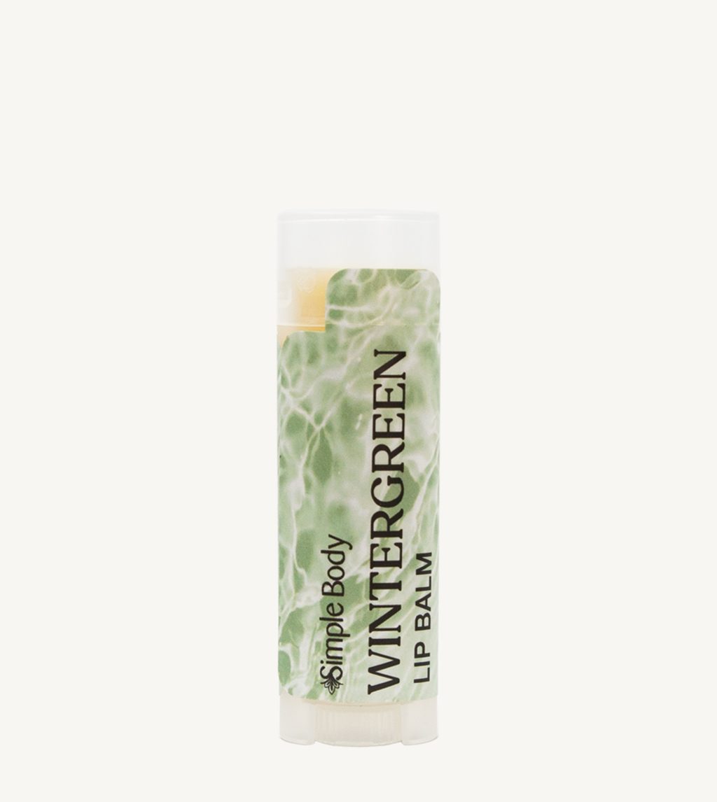 Photo of our Wintergreen Lip Balm. The label has a minty green color with a water texture in the background.